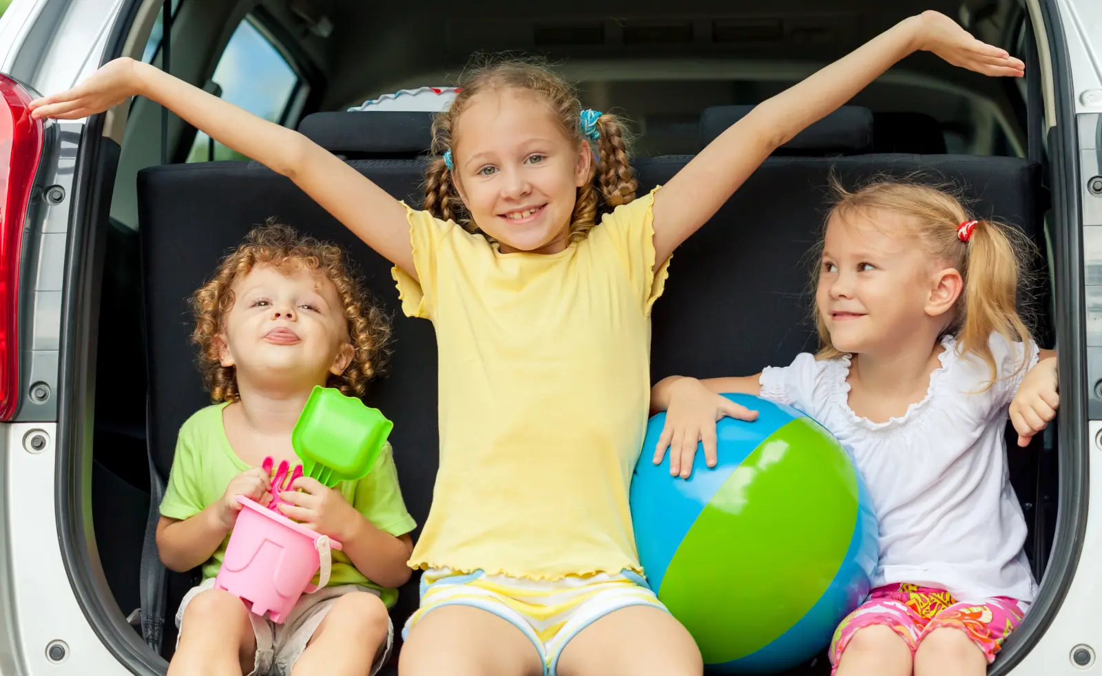 Kinder im Kofferraum auf der Urlaubsfahrt